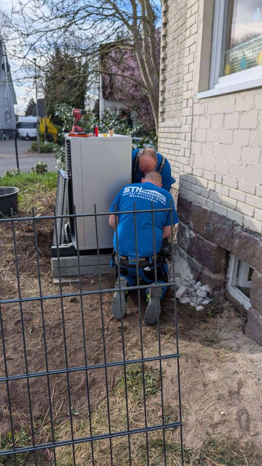 Monteur bei der Installation einer Wärmepumpe