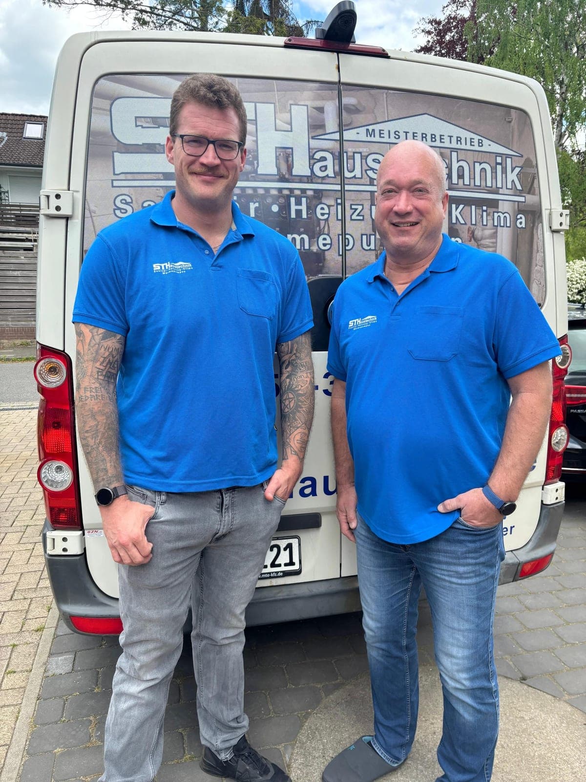 Vater und Sohn von ST-Haustechnik vor dem Firmenfahrzeug
